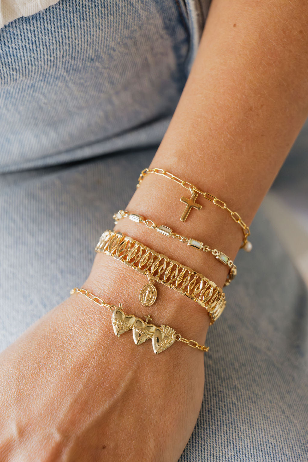 Gold charm bracelet set with cross, pearl beads, and a woven texture cuff