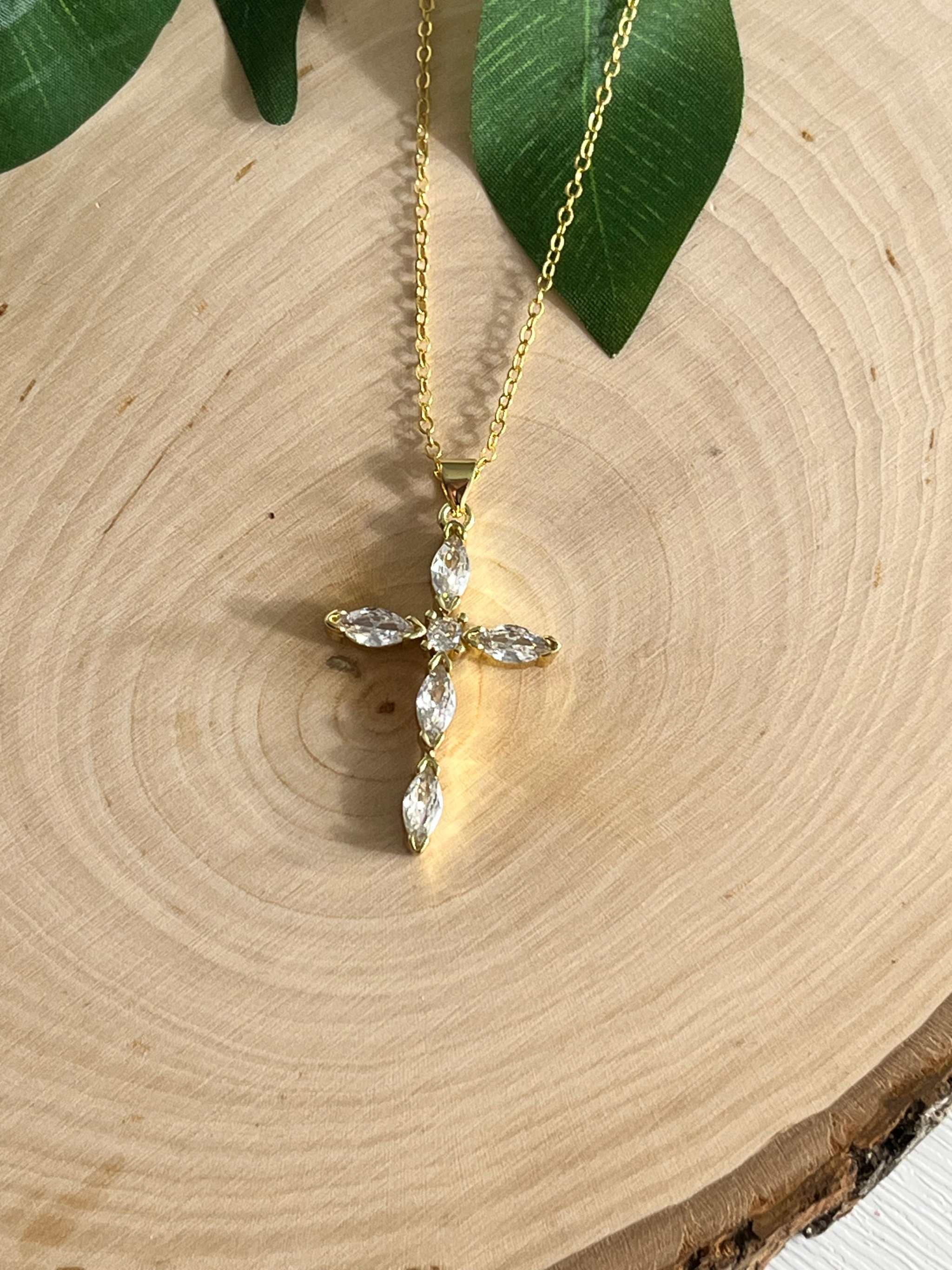 Gold cross pendant necklace with faceted crystal drops and a delicate chain
