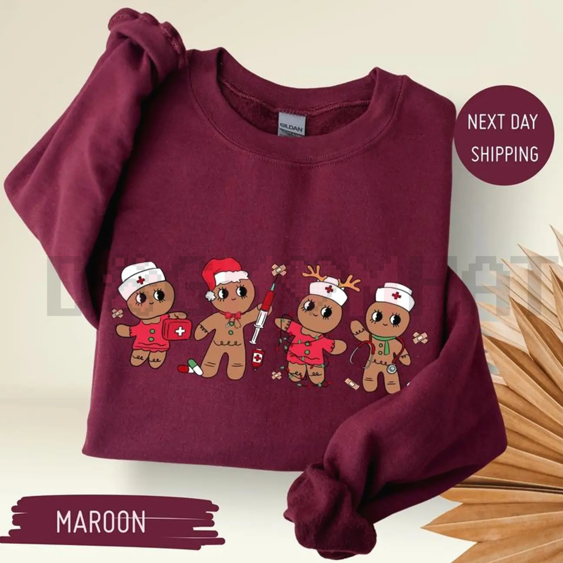 Maroon sweatshirt with cartoon gingerbread nurse characters graphic on front, long sleeves