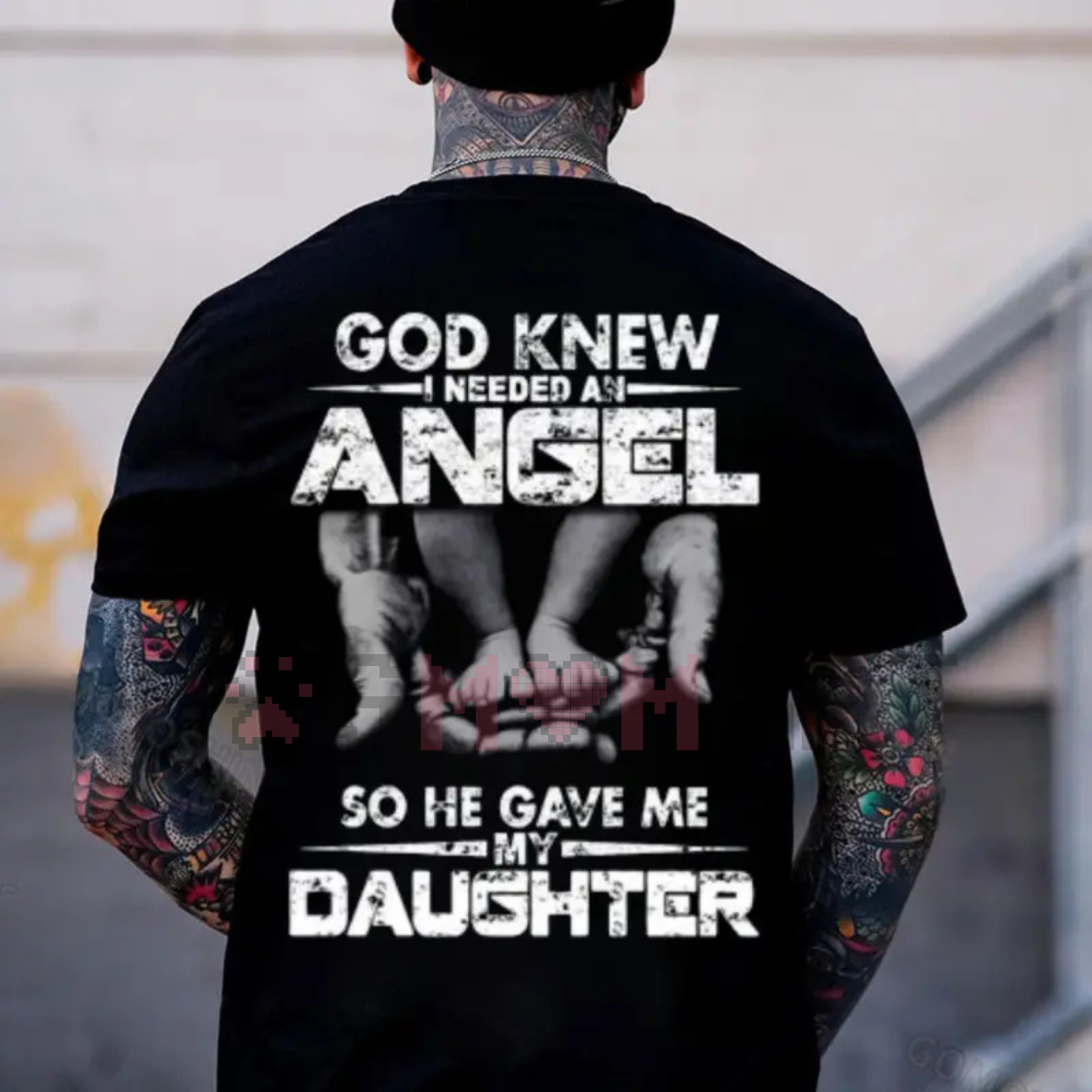 Black T-shirt with back graphic; tattoo-style sleeve art visible beneath