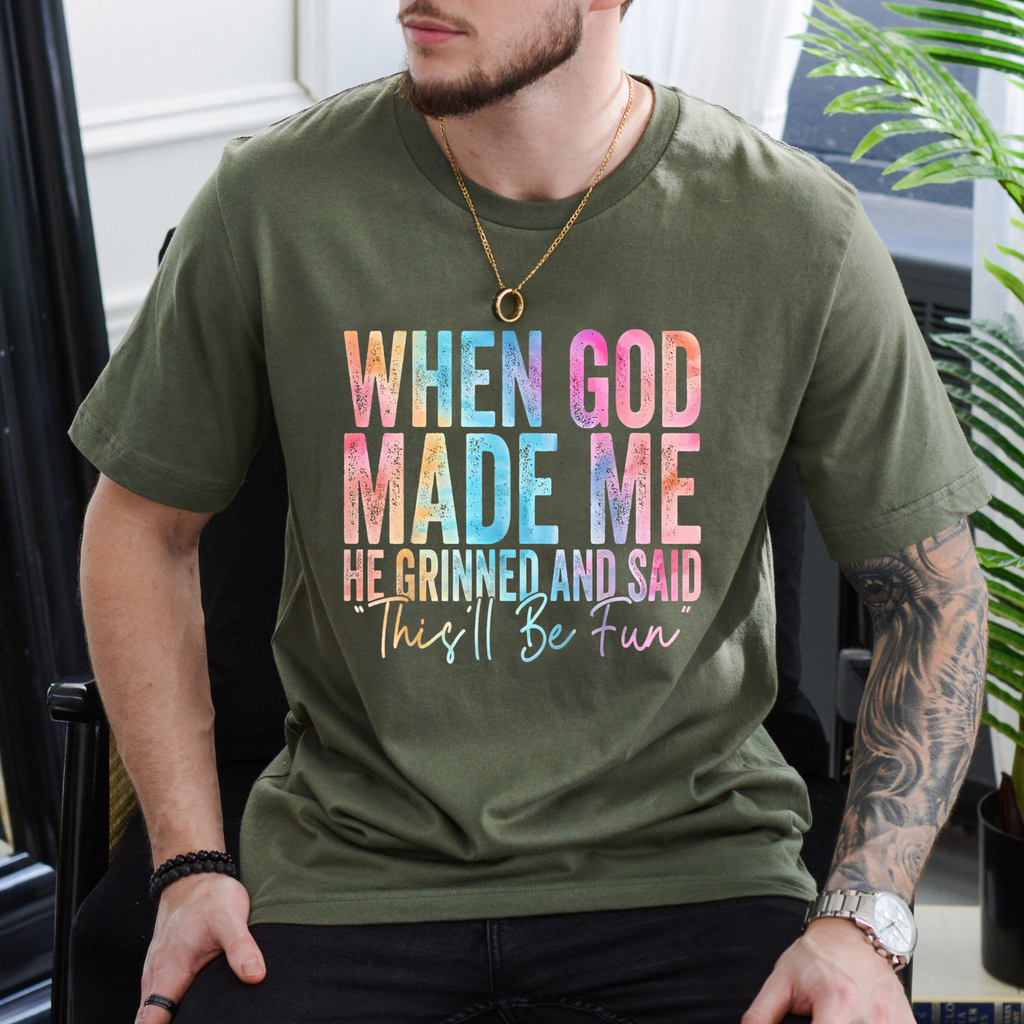 Olive T-shirt with colorful “When God Made Me” graphic quote on the front, crew neck