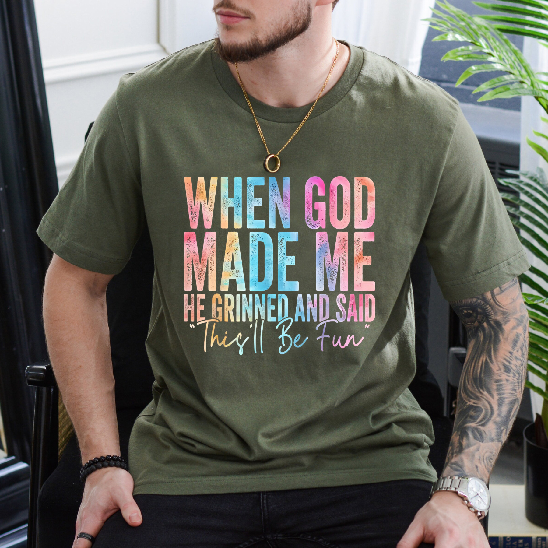 Olive T-shirt with colorful “When God Made Me” graphic quote on the front, crew neck