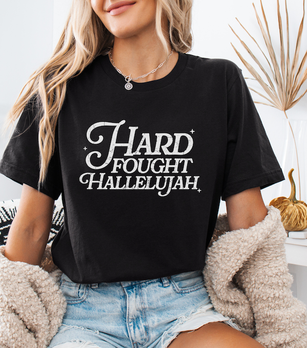 Black crewneck T-shirt with white script front graphic reading 'Hard Fought Hallelujah'