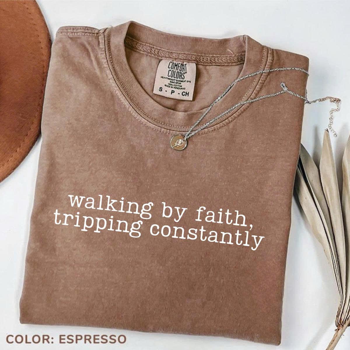 Women’s crewneck graphic tee, espresso brown with “walking by faith, tripping constantly”