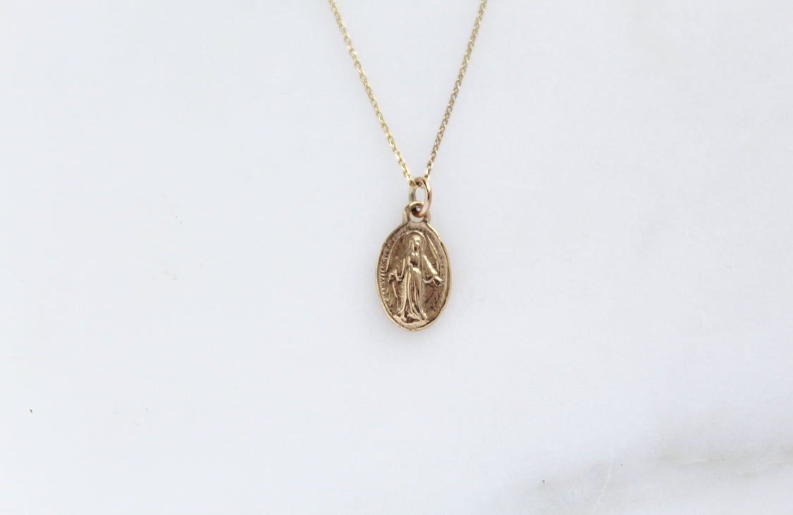 14k gold Miraculous medal necklace with oval pendant centered on chain