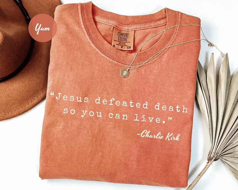 Rust crewneck T-shirt with 'Jesus defeated death' graphic and small pendant