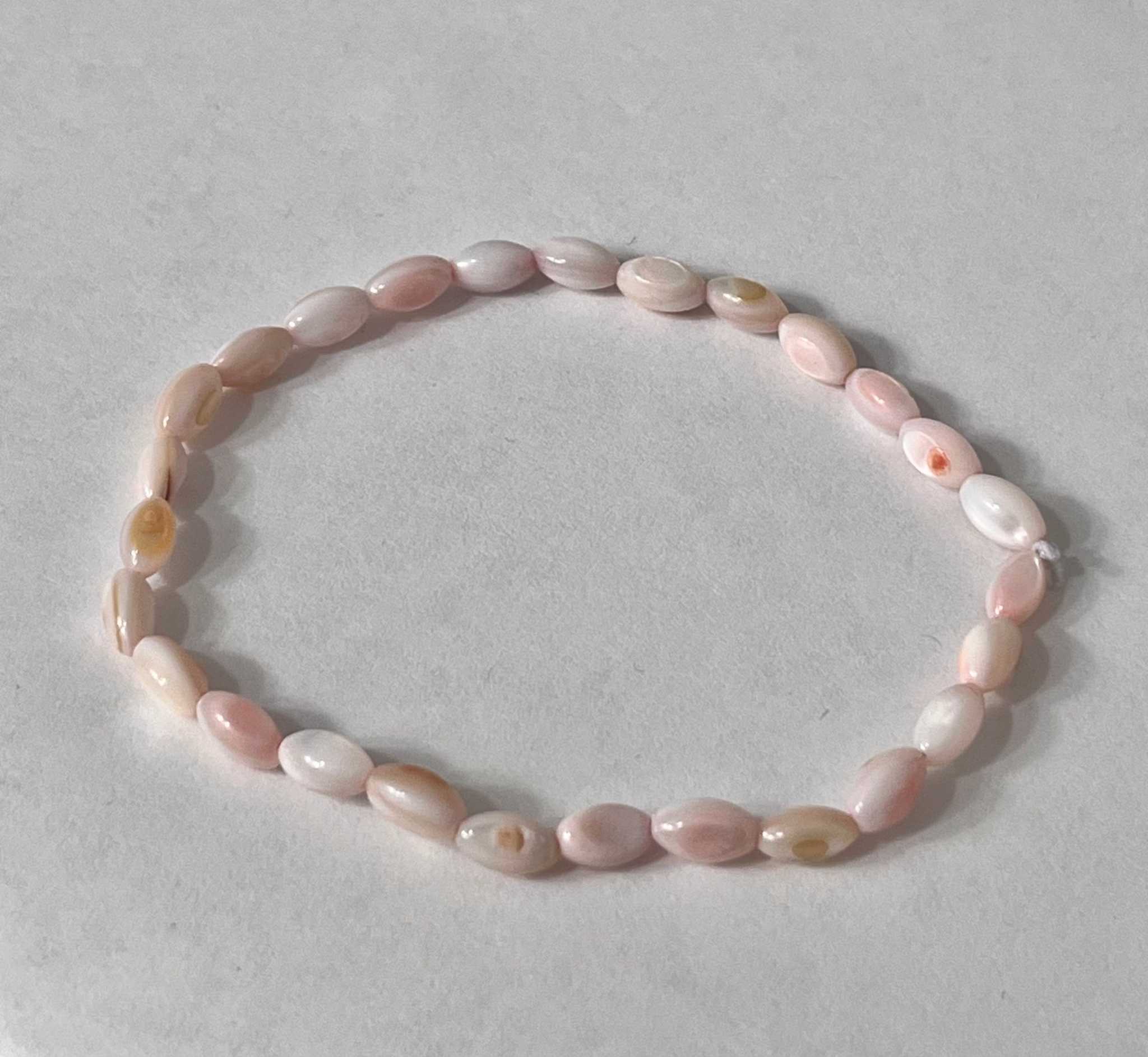 Bead bracelet with pink pearl-like oval beads and a smooth elastic fit