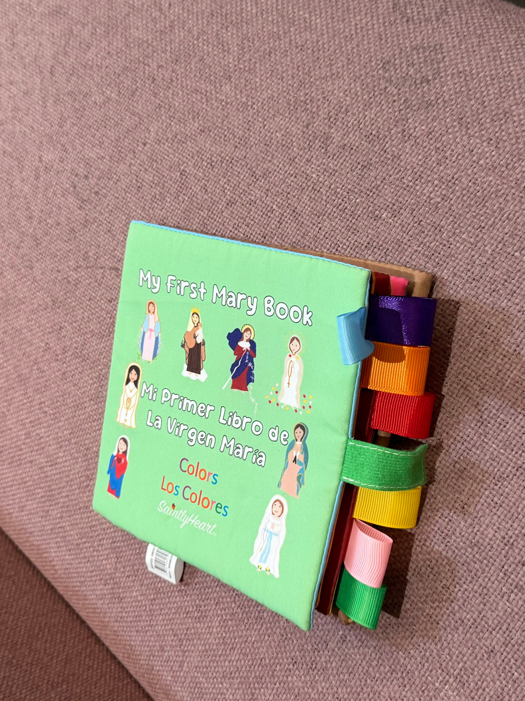 Children's board book with green cover and colorful ribbon tabs