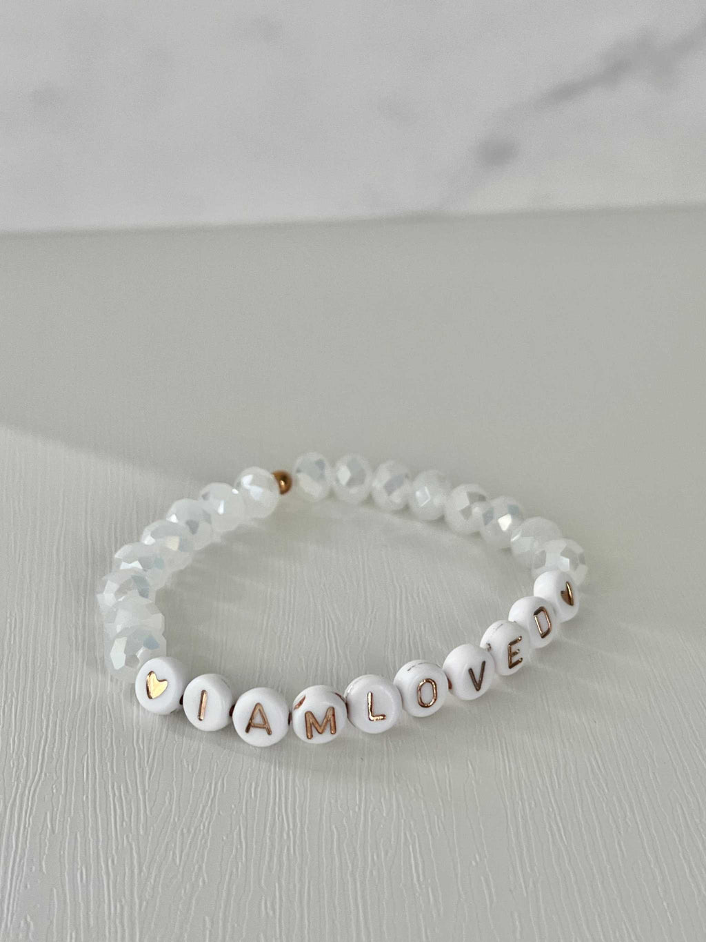 White beaded bracelet with 'I AM LOVED' letter beads and faceted crystal beads