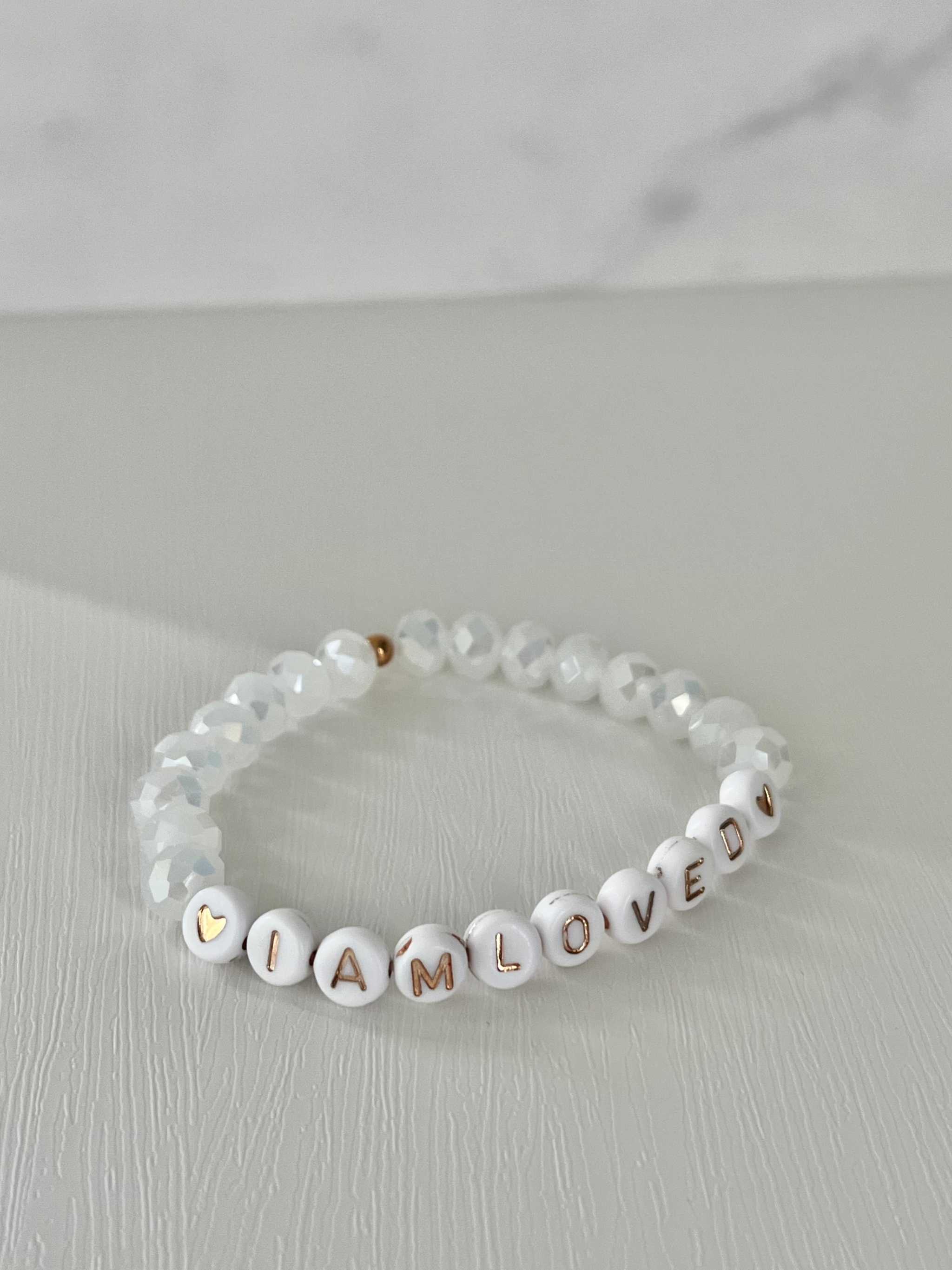 White beaded bracelet with 'I AM LOVED' letter beads and faceted crystal beads