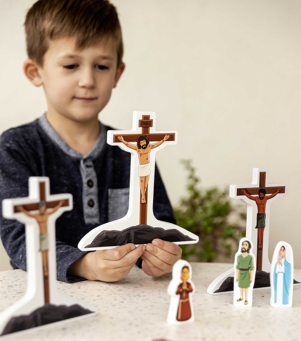 Child holding a cross piece from the Stations of the Cross pray & play set