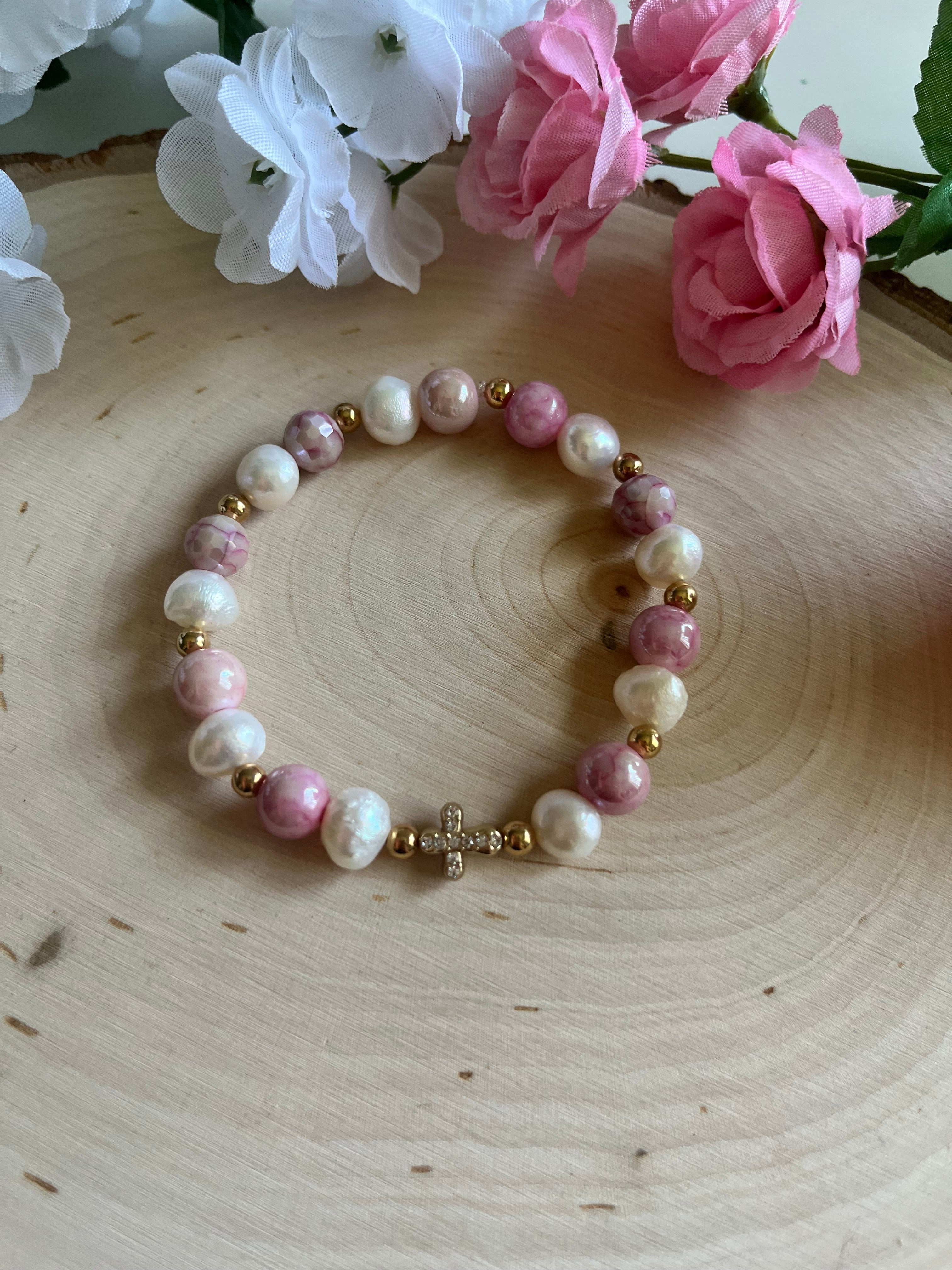 Pink and white pearl bead bracelet with gold cross charm in the middle