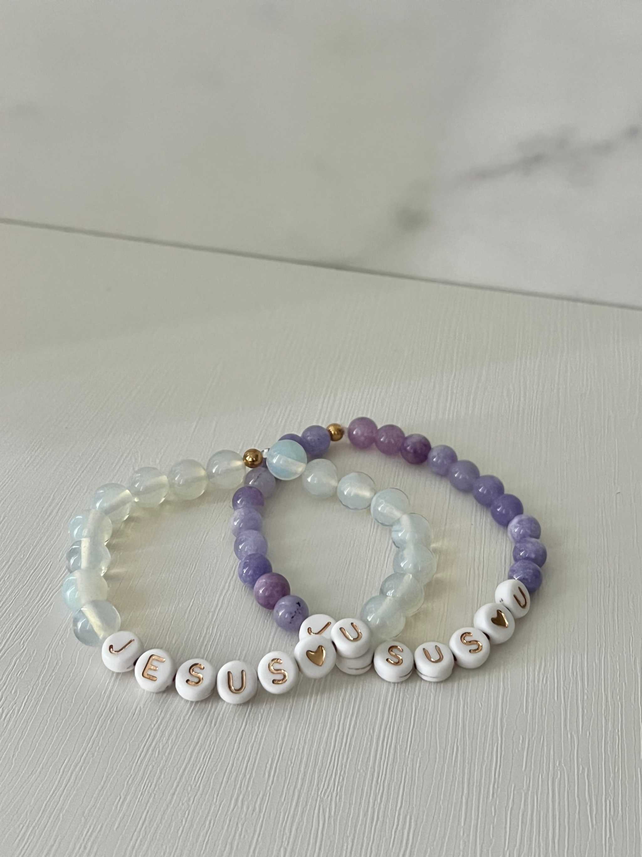 Bead bracelets set: purple and clear beads with white letter beads spelling "Jesus U"