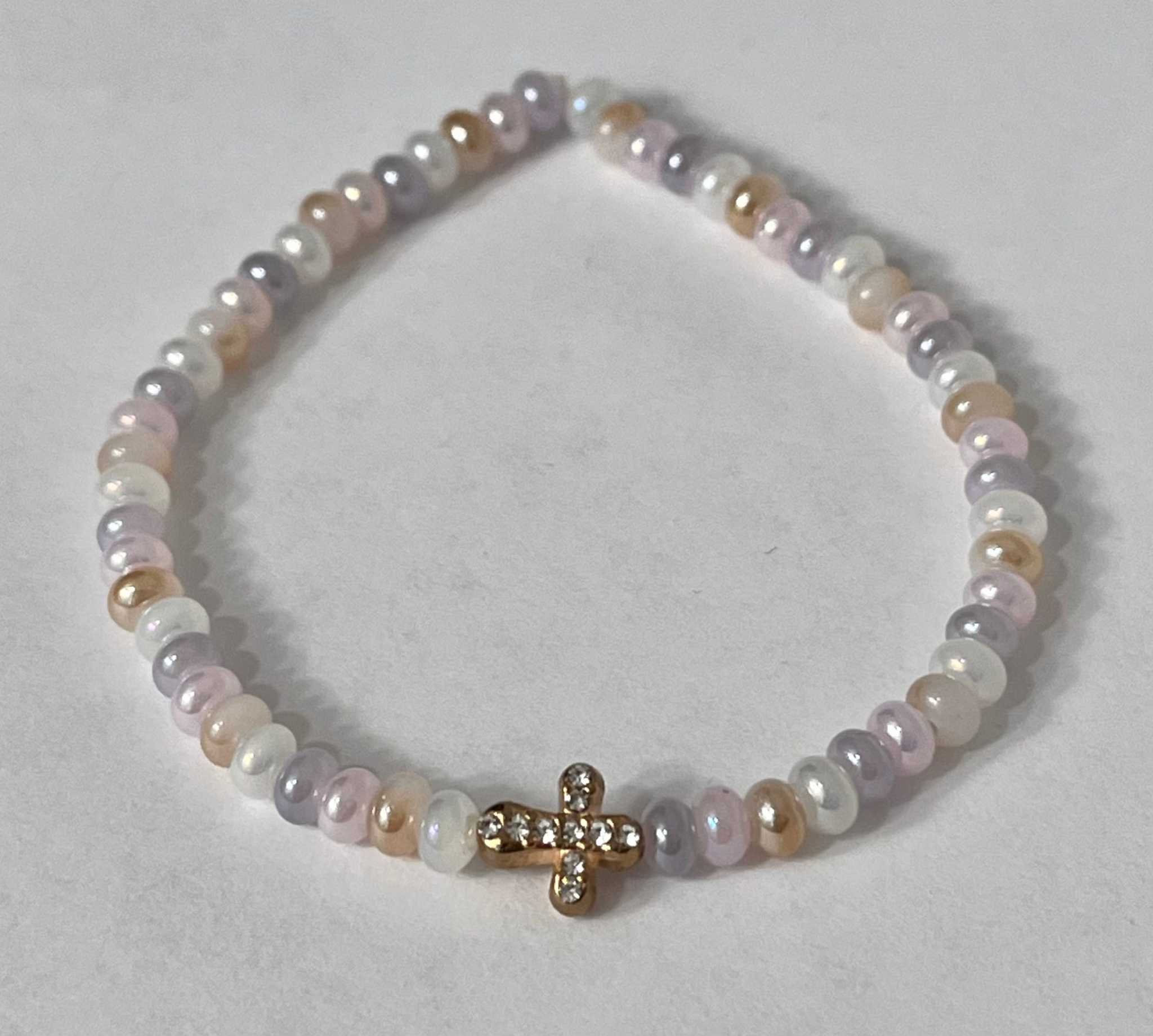 Bead bracelet with light purple and white beads and a gold cross charm