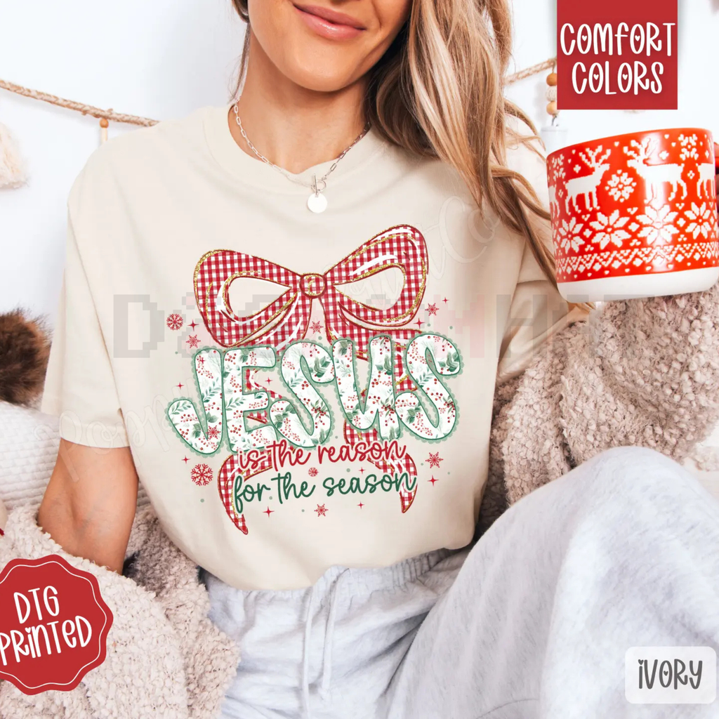 Ivory crewneck tee with red plaid bow and festive lettering graphic