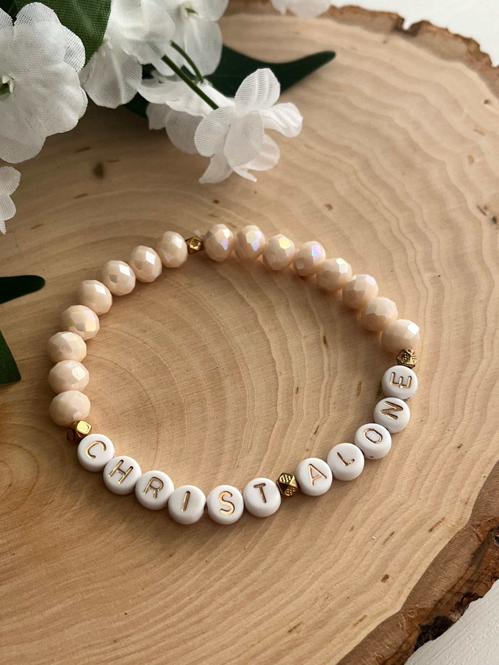 Peach bead bracelet with round letter beads spelling "CHRIST ALONE"
