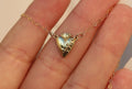 Gold heart pendant necklace with chain and flower-like detail at the top