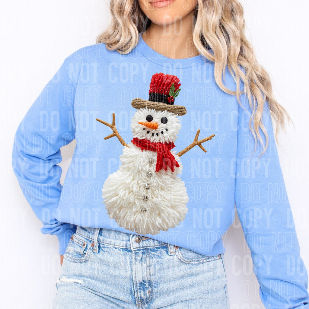 Light blue faux yarn snowman sweatshirt worn by model; full front snowman with red accents