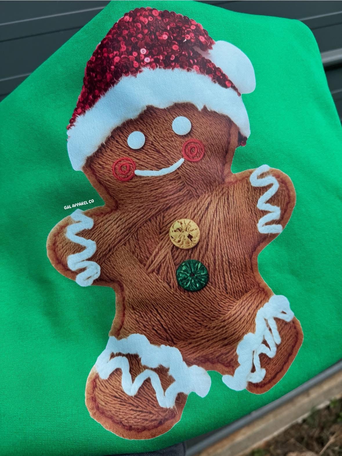 Green sweatshirt with gingerbread man faux yarn appliqué in winter hat and scarf