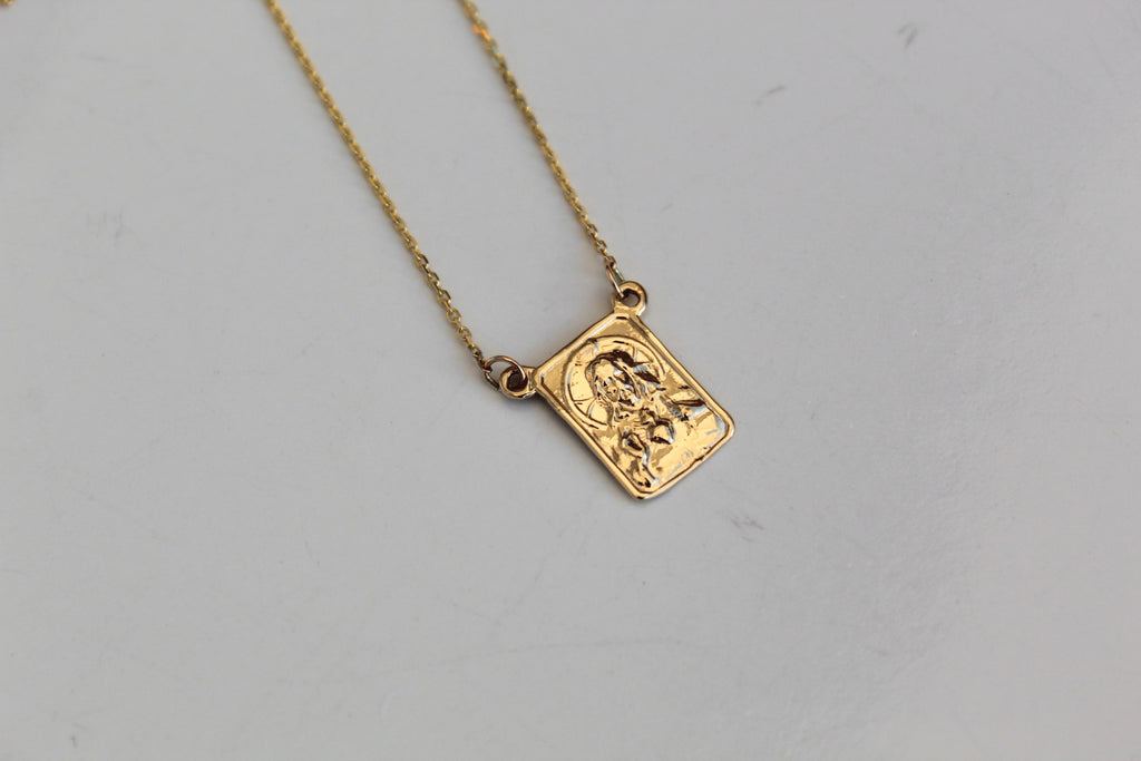 Square 14K gold scapular pendant with embossed figure on a delicate chain