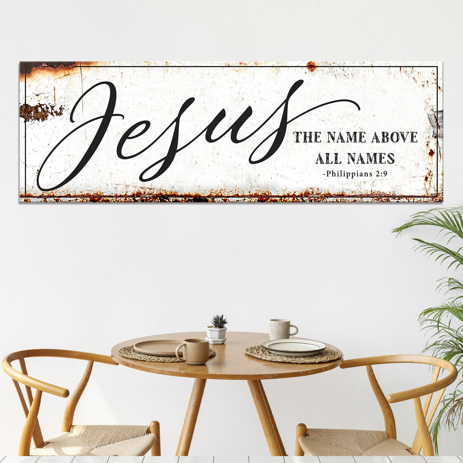 Framed Jesus wall art above dining table with 'The name above all names' and 'Philippians 2:9'