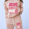 Peach long-sleeve top with 'Jesus Loves You' graphic on front