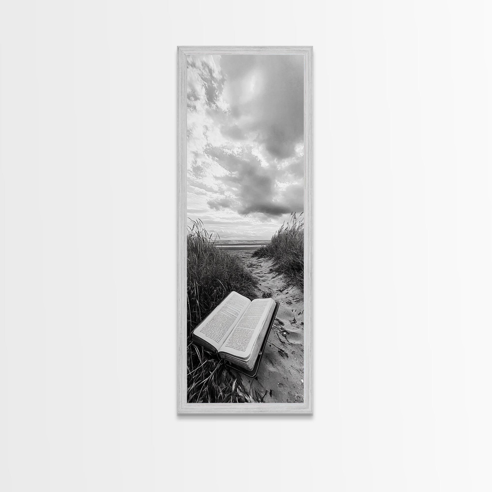 Gray framed canvas print of open Bible on a sandy beach path under cloudy sky