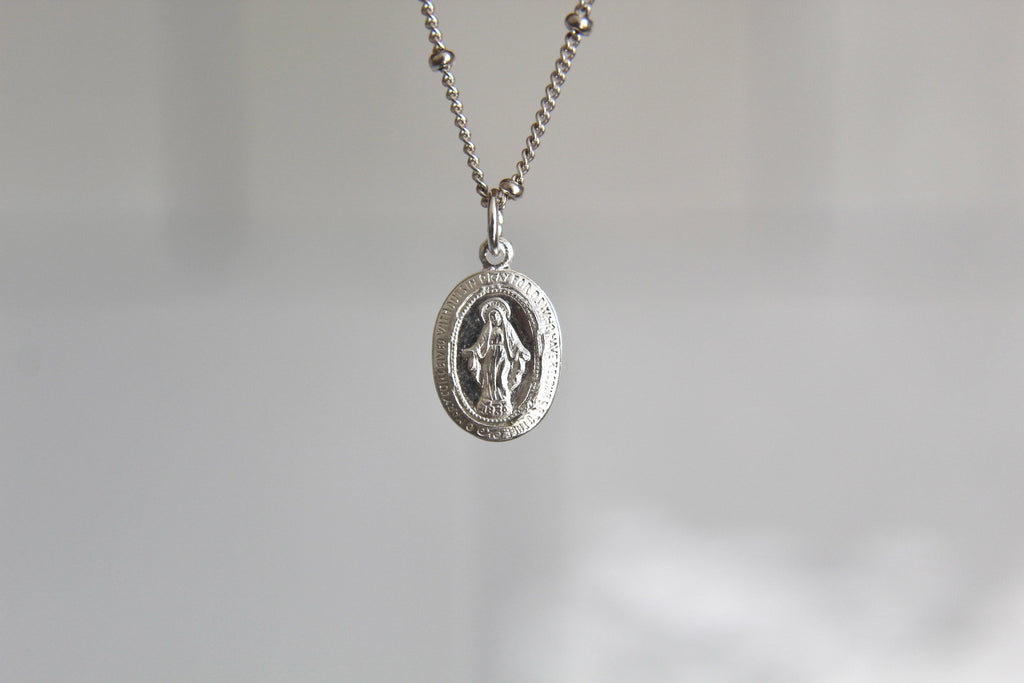 Silver miraculous medal necklace with oval pendant and fine chain links