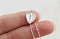 Sterling silver shield pendant with Virgin Mary figure and cable chain, close-up