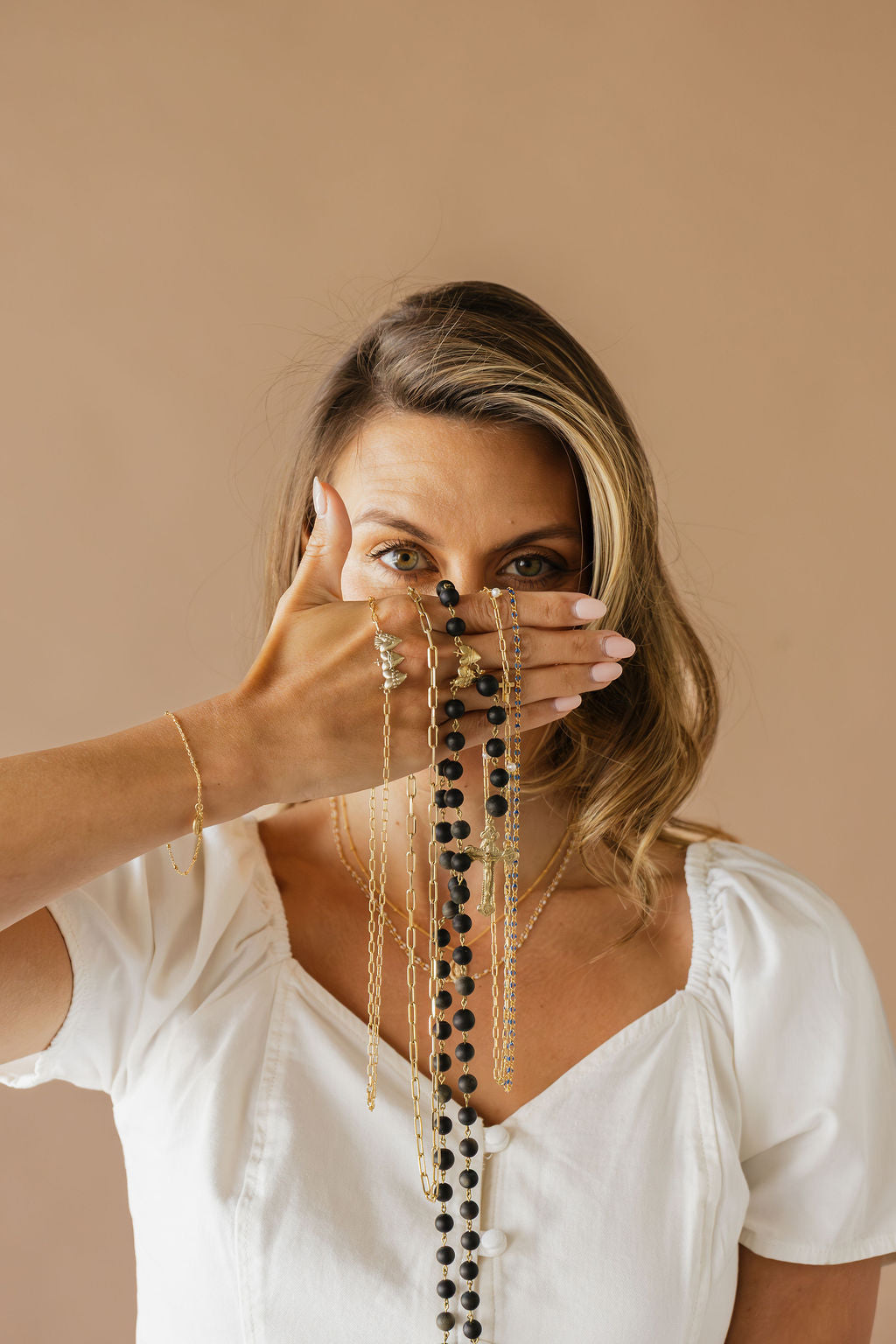 Long gold-tone necklace with layered black bead strands and dangling chains