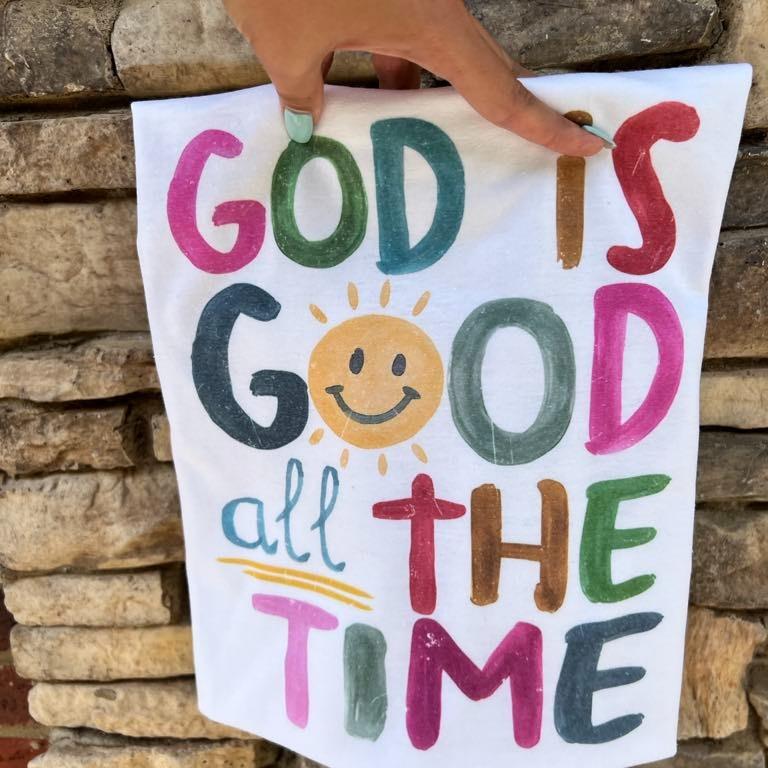 White Christian graphic T-shirt with colorful 'God is Good all the time' lettering