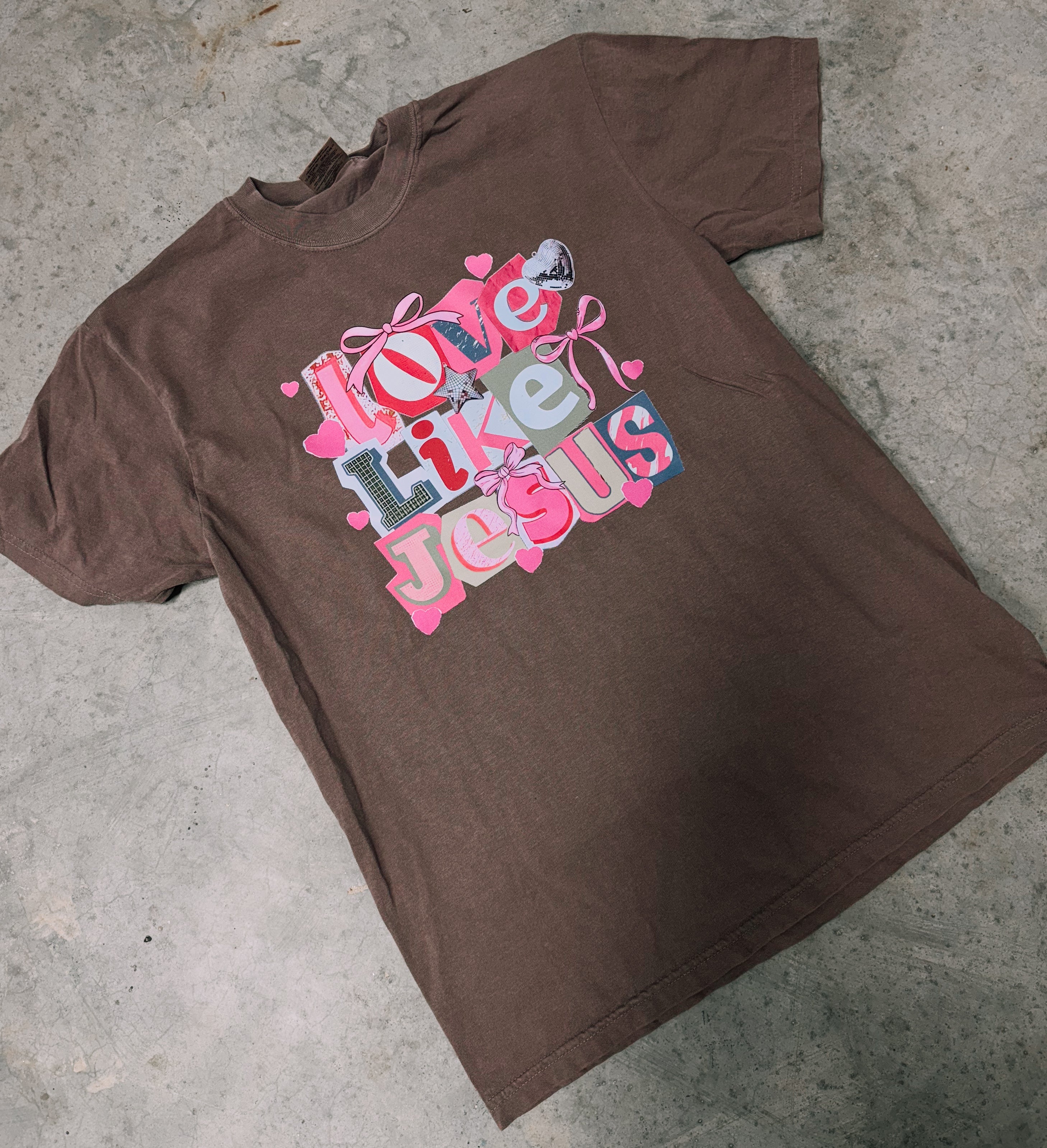 Dark brown short-sleeve graphic T-shirt with centered 'Love Like Jesus' text print