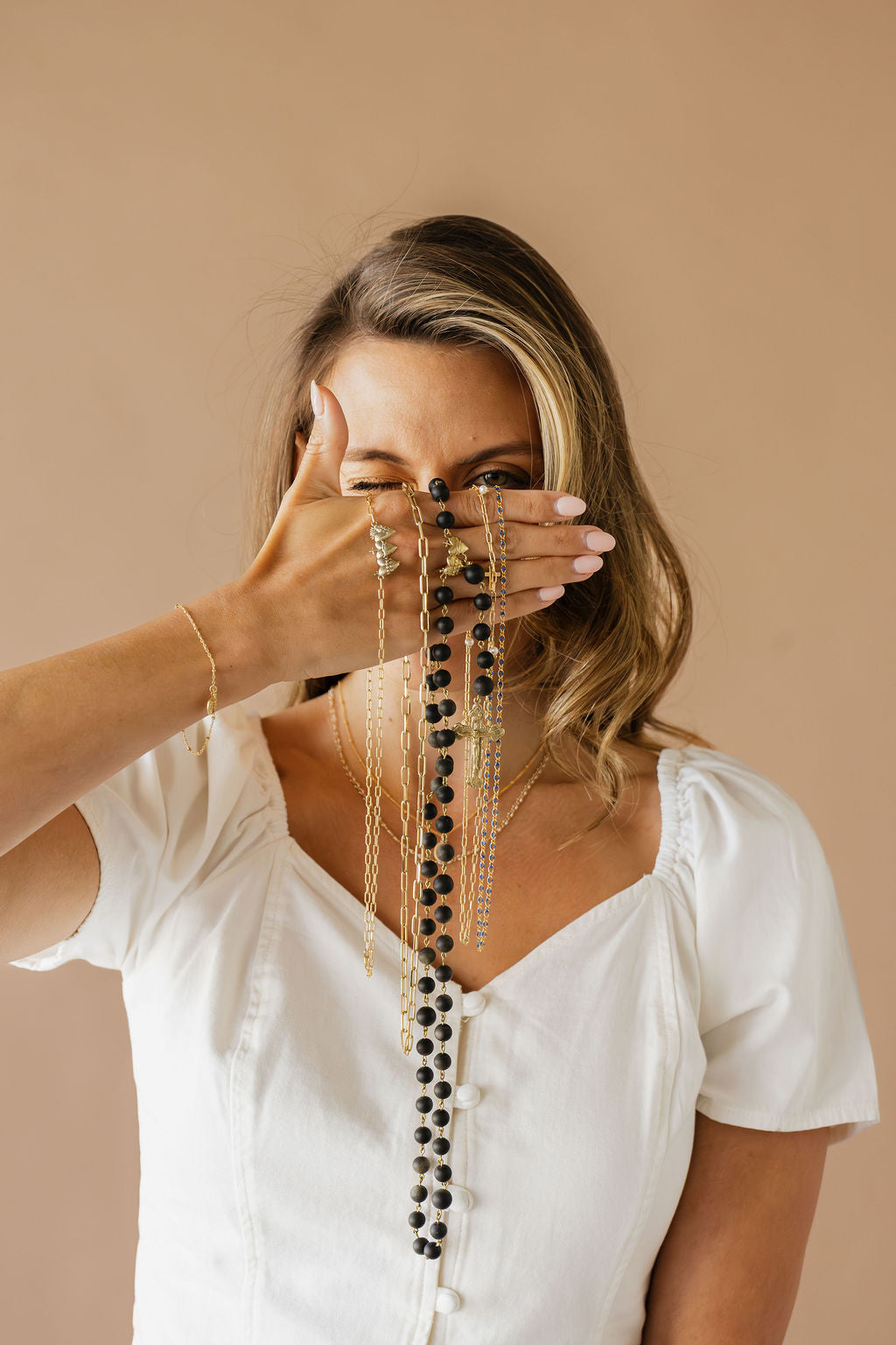 Layered long necklace with black bead center strand and gold-tone side chains