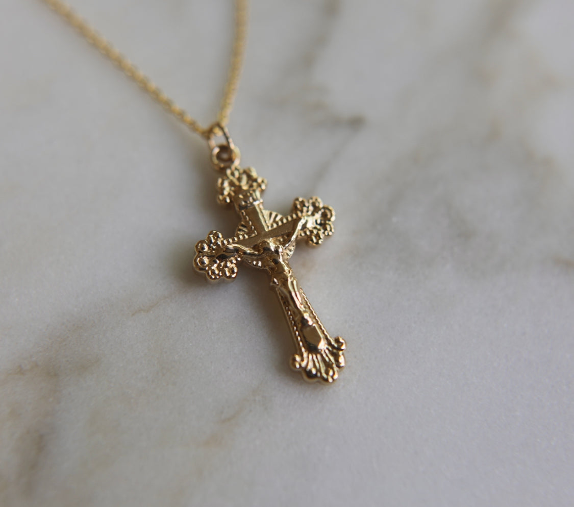 14k gold crucifix pendant on a chain, side angle showing cross details.