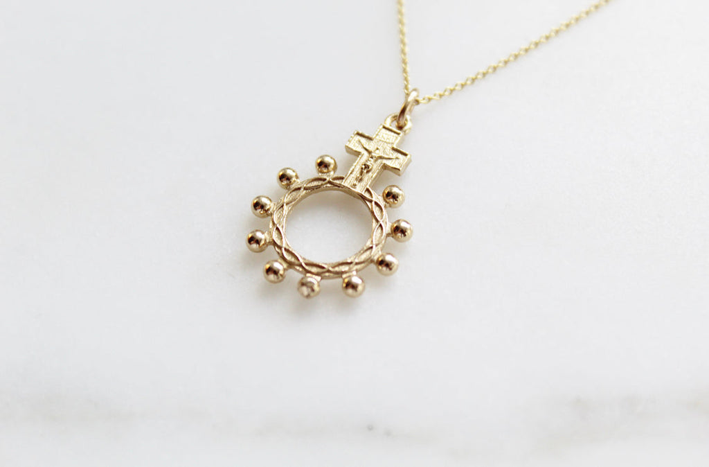 14k gold rosary bead necklace pendant showing circular ring with bead drops and a cross