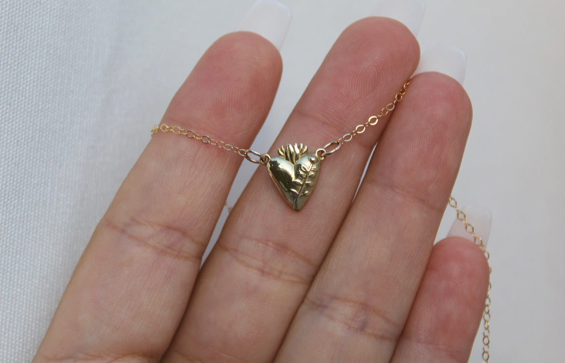 Gold-tone heart pendant necklace front view on hand