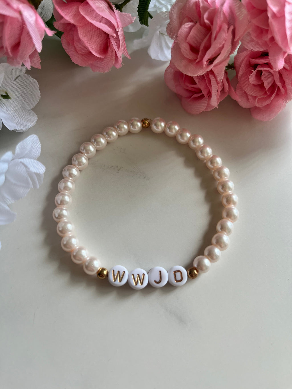 Pearl bead bracelet with WWJD letter beads on white round pearl strands.