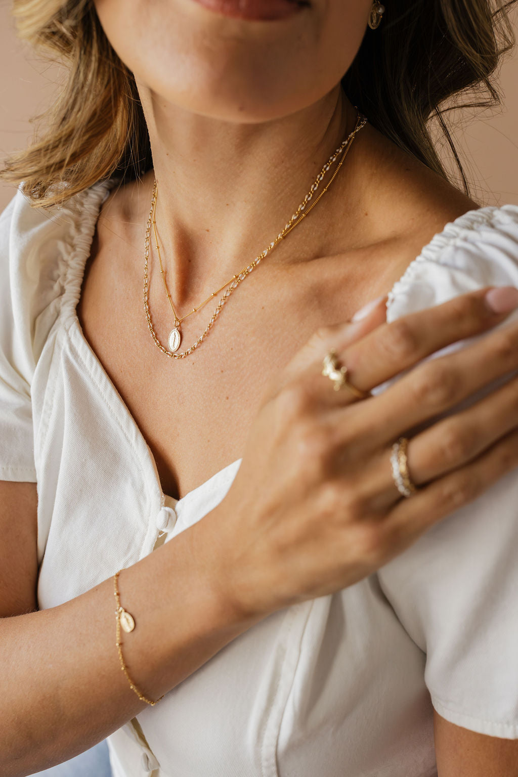 Gold chain necklace with oval medal pendant on the chest, close framing