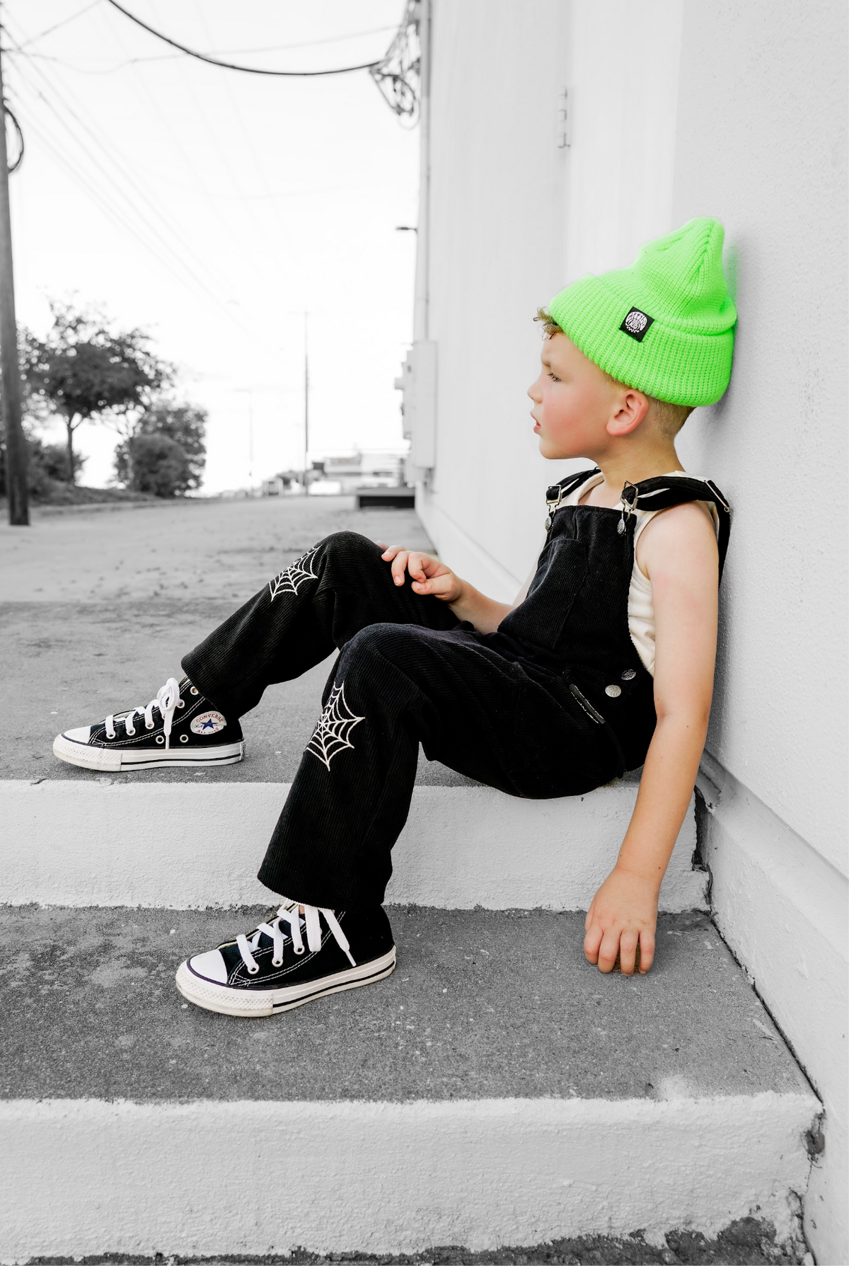 Black spiderweb overalls with adjustable straps and web patch on pants.