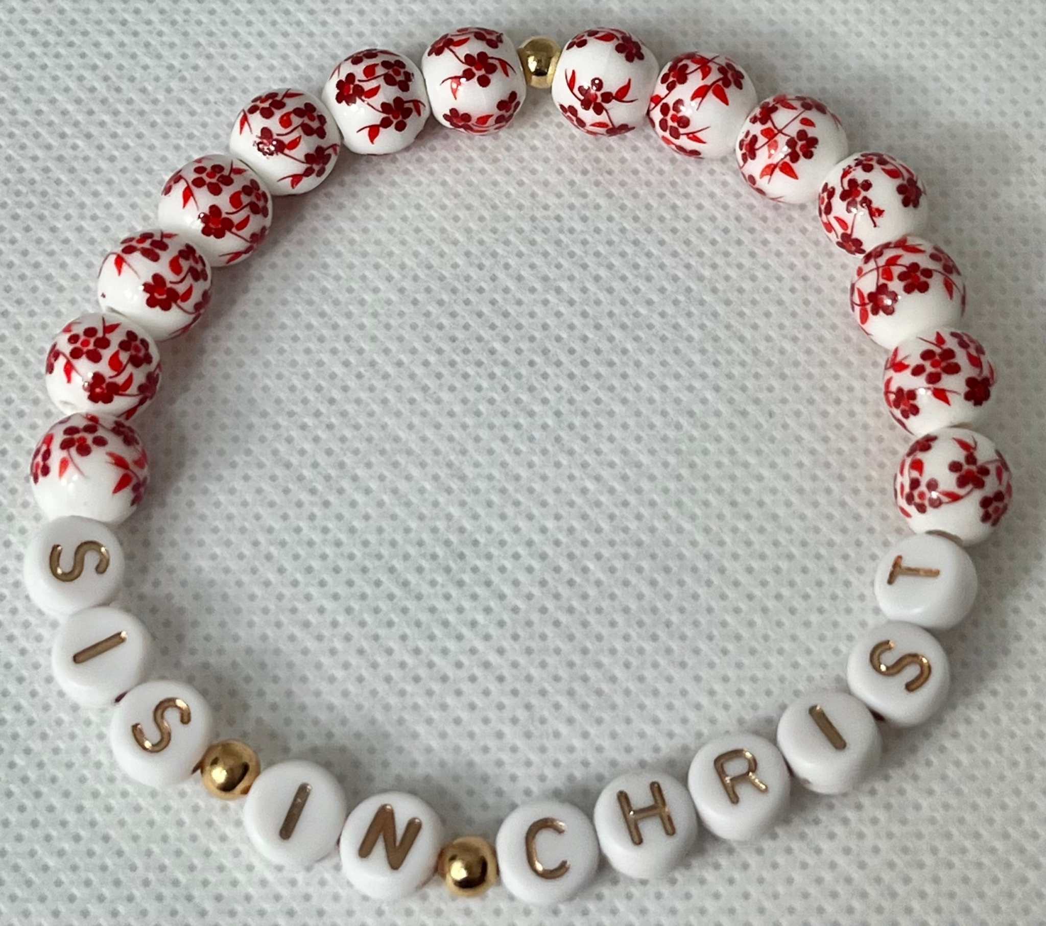 Red and white bead bracelet with gold spacers and letters spelling IN CHRIST