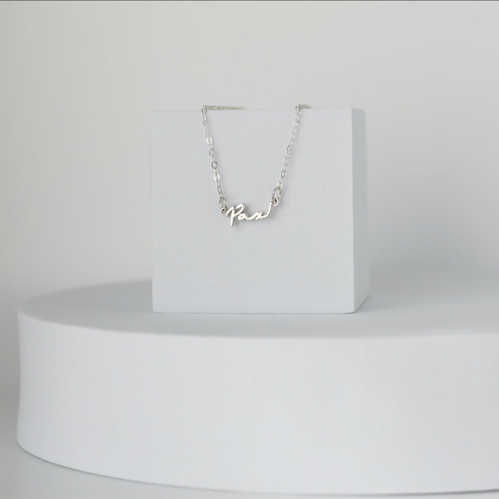 Sterling silver Pax necklace with cursive Pax pendant, front view on a fine chain
