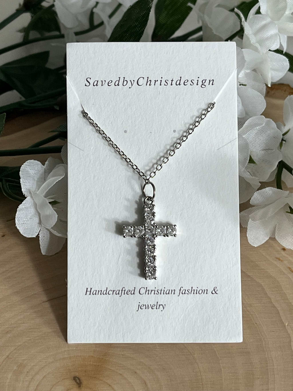 Silver cross pendant necklace displayed on a card with rhinestone cross pendant