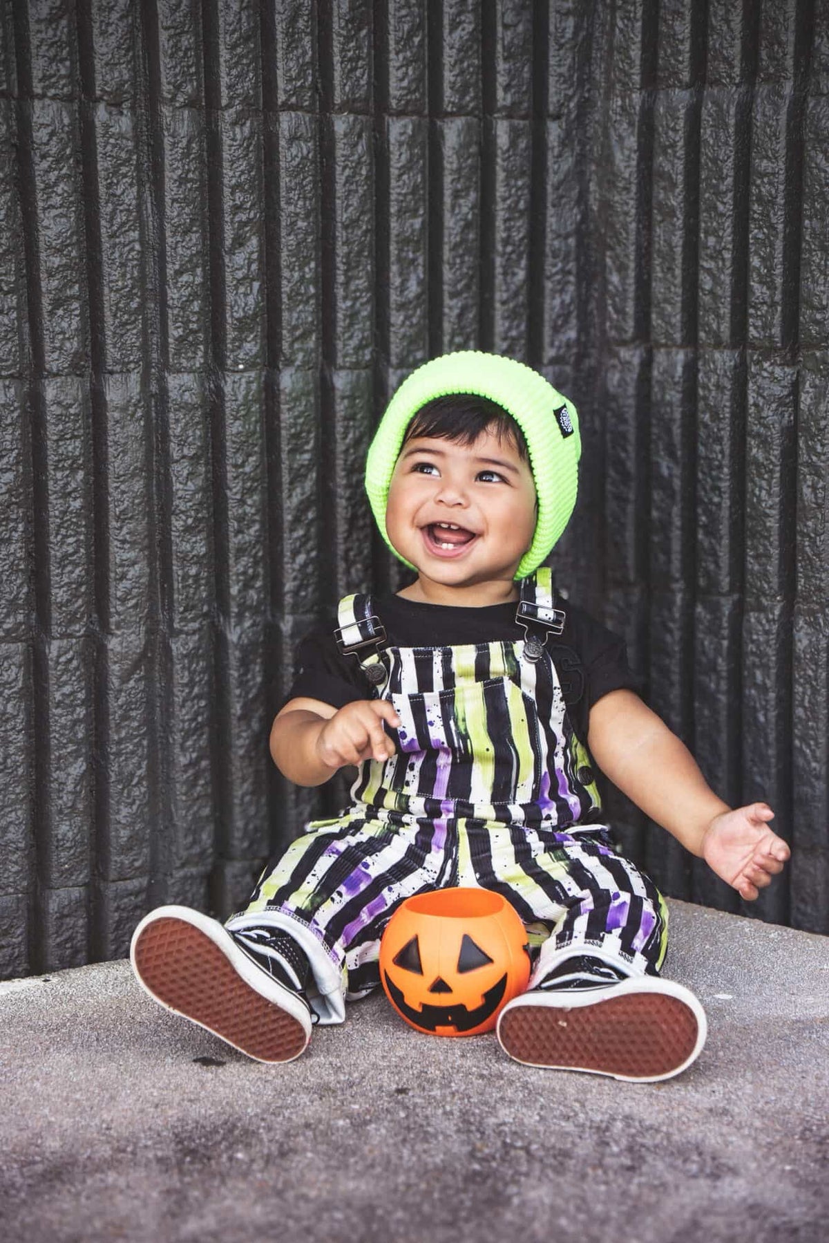 Kids striped Halloween overalls with neon green and purple accents and front pocket