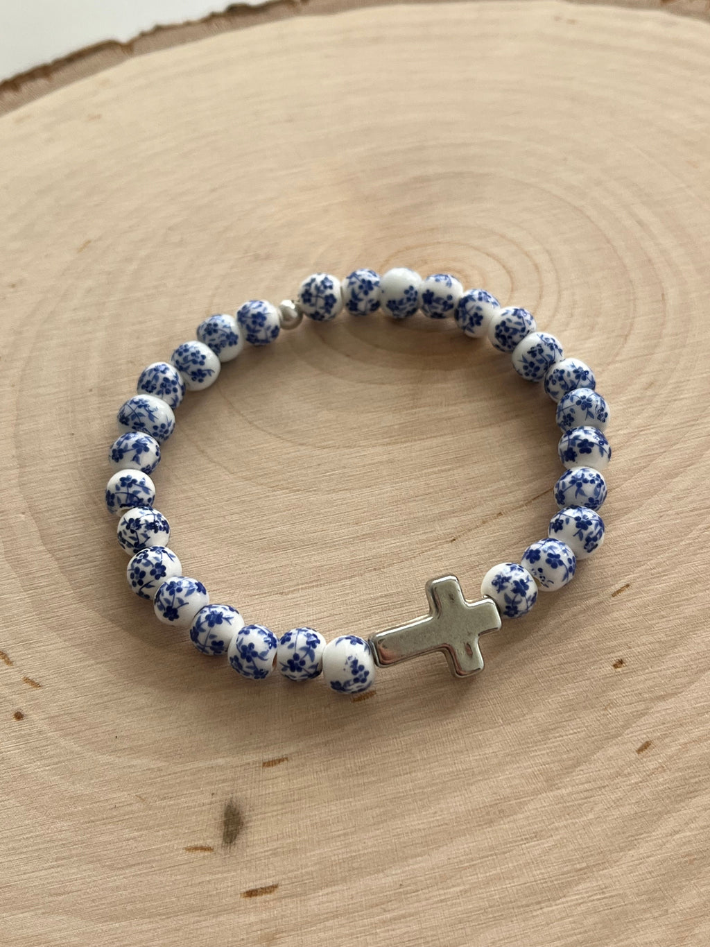 Blue and white speckled bead cross bracelet with silver cross charm, stretchy fit.