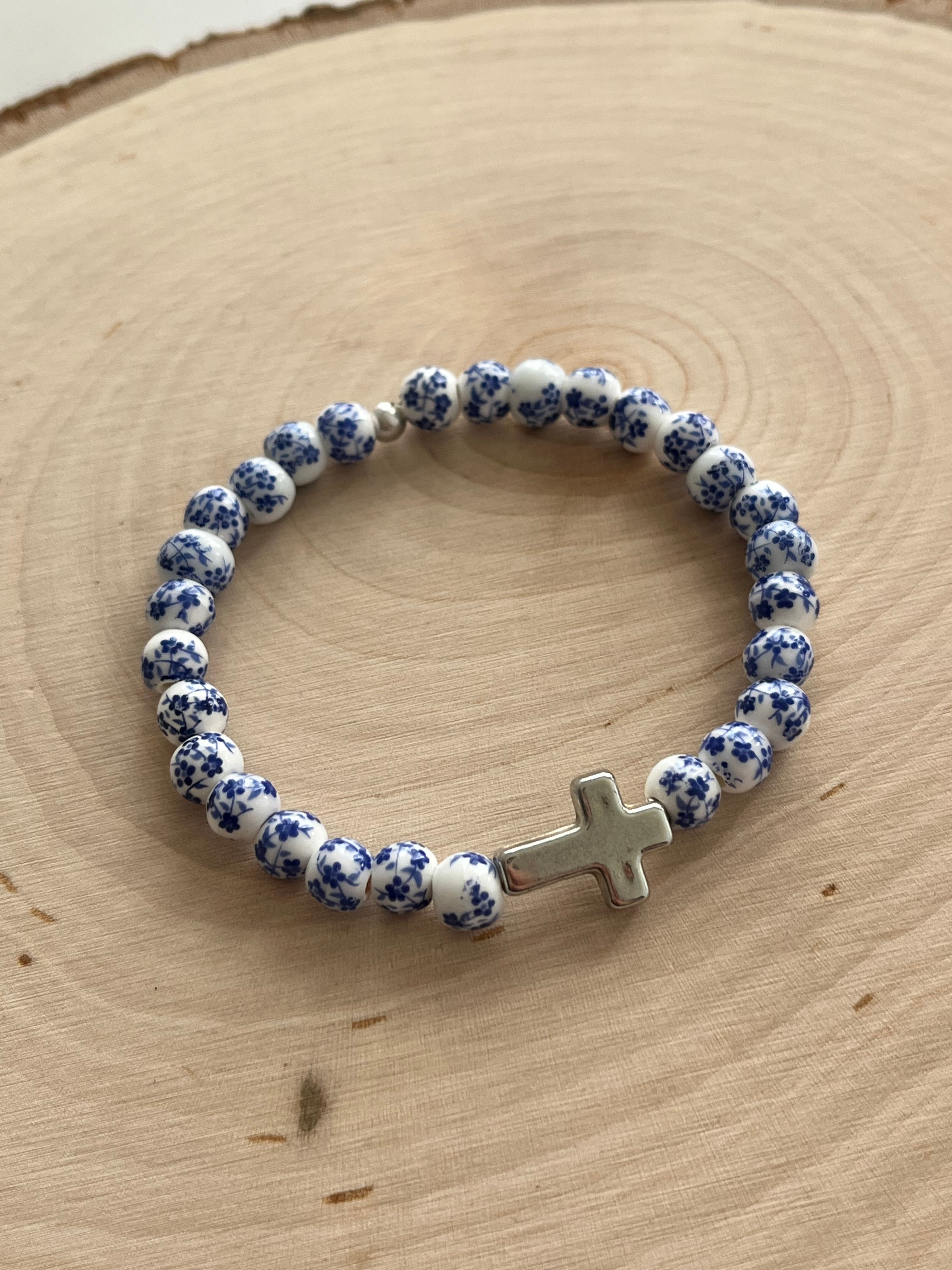 Blue and white speckled bead cross bracelet with silver cross charm, stretchy fit.