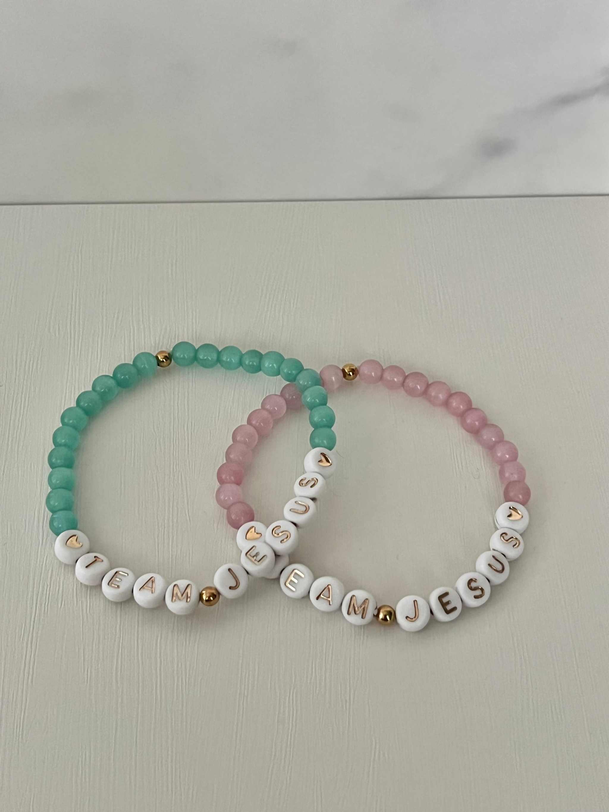 Opal-like iridescent beaded bracelet with teal beads and white letter charms