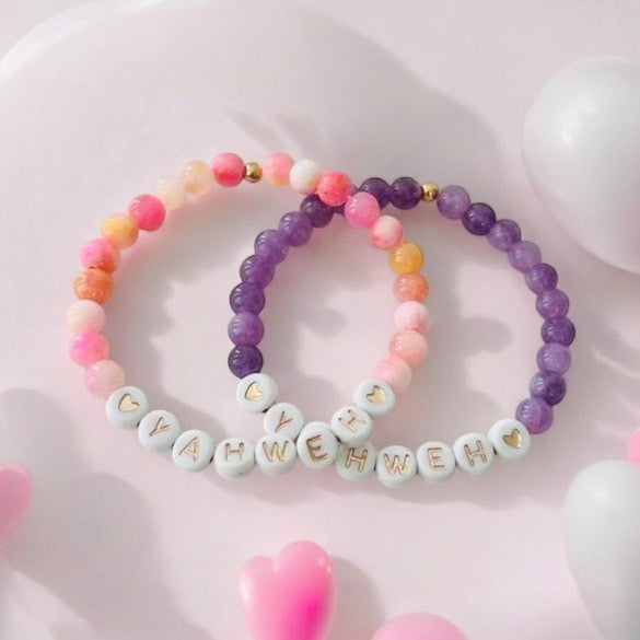 Beaded stretch bracelet set with pink and purple beads, white letter charms spelling YAHWEH.