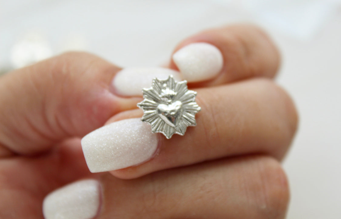 Silver-tone sacred heart stud earring with starburst heart medallion