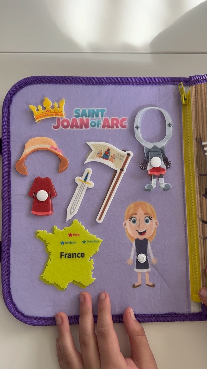 Busy book page with Saint Joan of Arc felt pieces, cross, map patch, and character figures