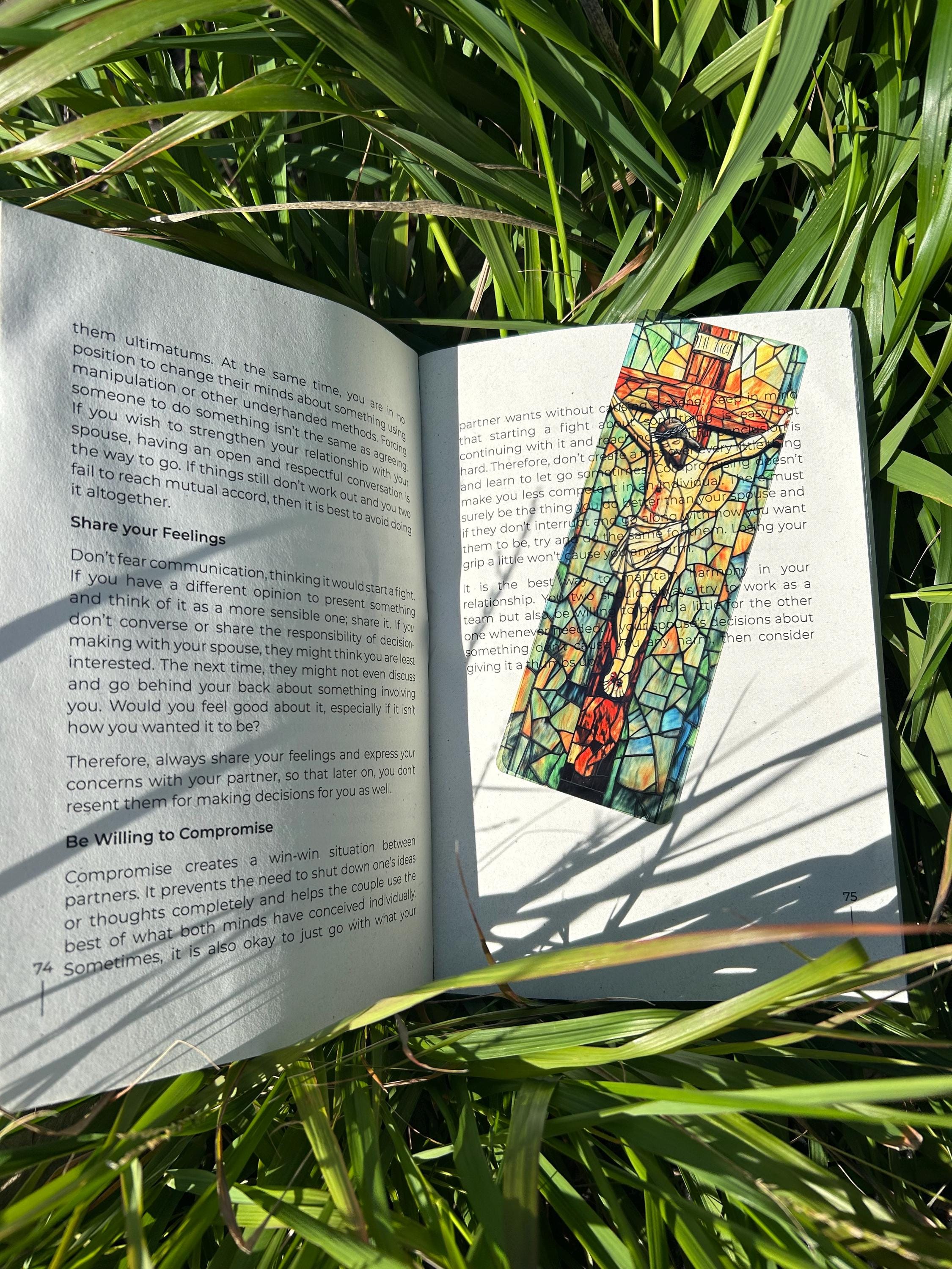 Handmade Jesus bookmark with stained-glass artwork, marking a book page